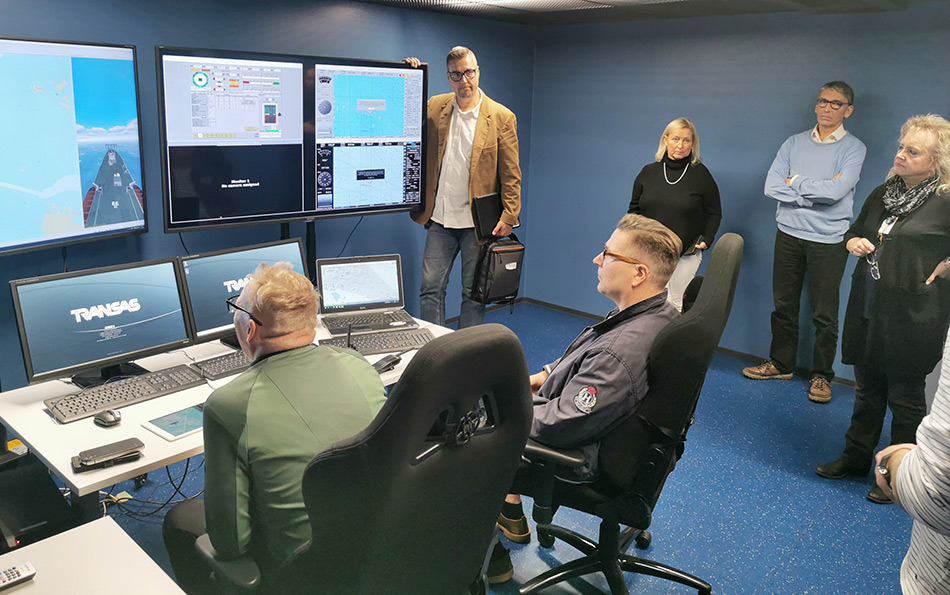 Group of maritime expertises front of monitors in maritime simulator.